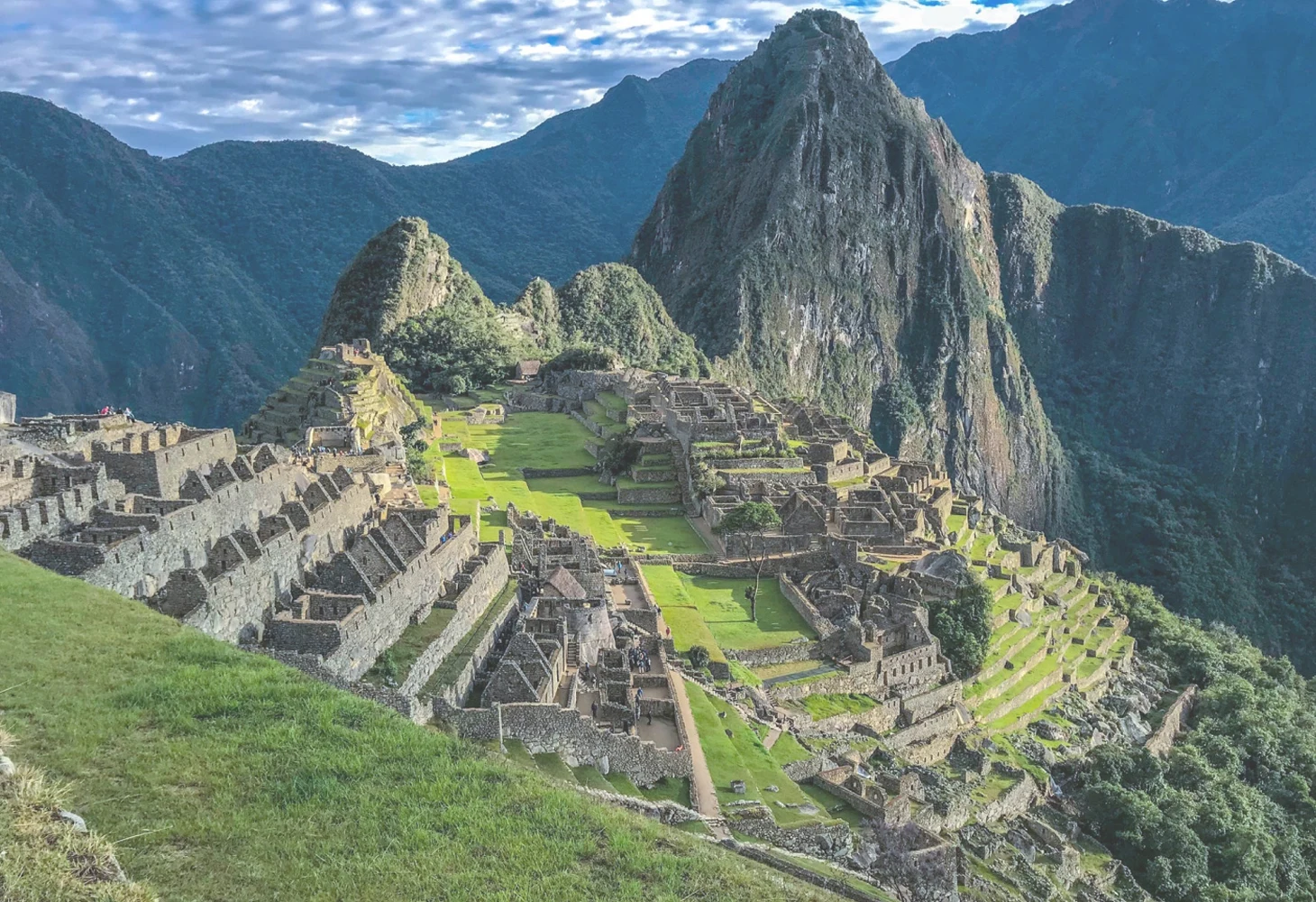 Ciudadela de Machu Picchu al amanecer con luz dorada sobre las montañas de Cusco, Perú